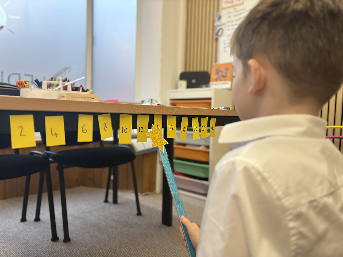 A child uses a pointer to follow a number line in a learning session